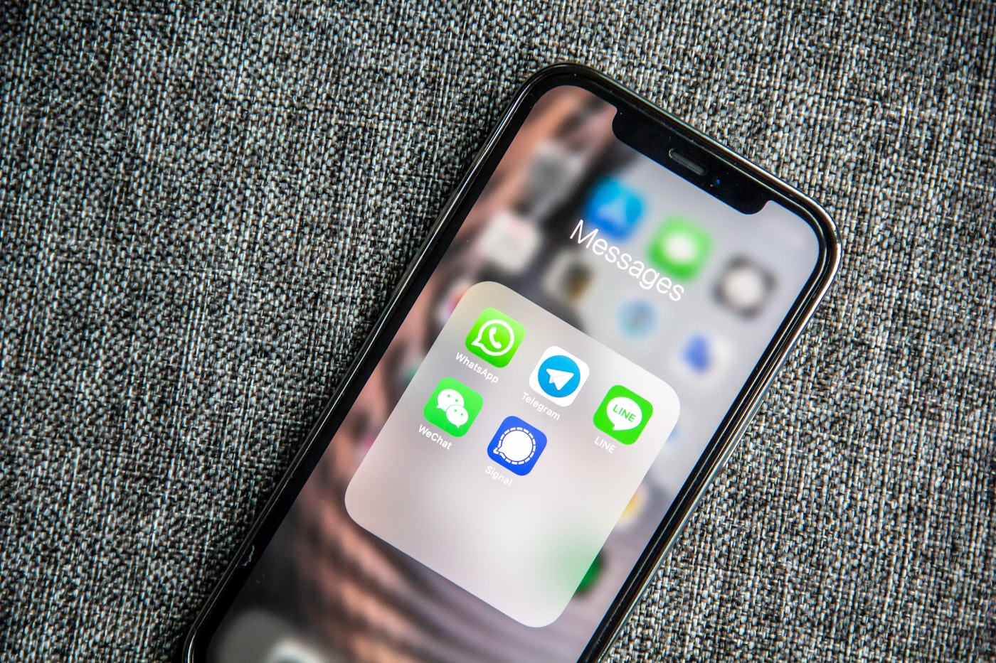 A hand holding a smartphone with a chat conversation open — an admissions query replied to within seconds